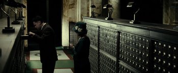 Movie still from “J. Edgar” (2011), directed by Clint Eastwood – A woman standing in front of an old - fashioned card catalog; Wide shot, Low angle