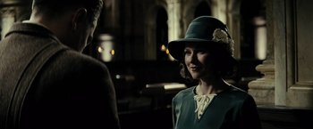 Movie still from “J. Edgar” (2011), directed by Clint Eastwood – A woman wearing a green hat and a white dress; Close Up shot, Over the shoulder angle