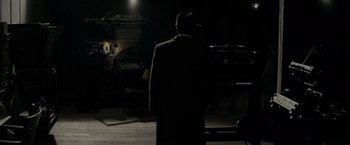 Movie still from “J. Edgar” (2011), directed by Clint Eastwood – A man wearing a hat and a long black coat; Wide shot, High angle