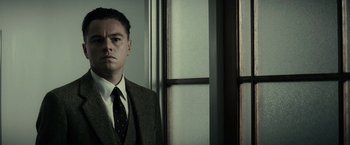 Movie still from “J. Edgar” (2011), directed by Clint Eastwood – A man wearing a suit and tie standing in front of a window; Close Up shot, Low angle