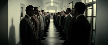 Movie still from “J. Edgar” (2011), directed by Clint Eastwood – A group of men in suits standing in a hallway; Wide shot, High angle