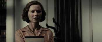 Movie still from “J. Edgar” (2011), directed by Clint Eastwood – A woman in a brown shirt holding a piece of paper; Close Up shot, Over the shoulder angle
