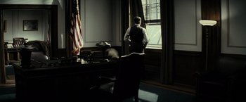 Movie still from “J. Edgar” (2011), directed by Clint Eastwood – A man standing in front of an open window in an office; Wide shot, Low angle
