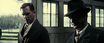 Movie still from “J. Edgar” (2011), directed by Clint Eastwood – Two men standing next to each other in front of a window; Close Up shot, Low angle