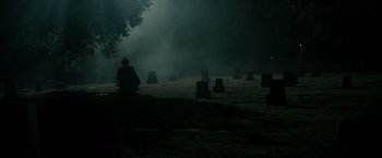 Movie still from “J. Edgar” (2011), directed by Clint Eastwood – A man sitting in a field near a tree; Extreme Wide shot, High angle