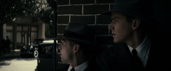Movie still from “J. Edgar” (2011), directed by Clint Eastwood – A couple of men in suits and hats next to a brick wall; Close Up shot, Low angle