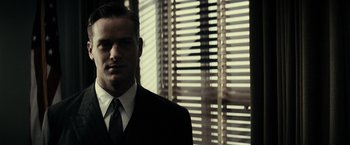 Movie still from “J. Edgar” (2011), directed by Clint Eastwood – A man wearing a suit and tie standing in front of a window; Close Up shot, Low angle