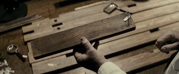 Movie still from “J. Edgar” (2011), directed by Clint Eastwood – A person holding a piece of wood in their hand; Extreme Close Up shot, Overhead angle