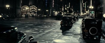 Movie still from “J. Edgar” (2011), directed by Clint Eastwood – A street scene at night with cars driving down the road; Extreme Wide shot, High angle