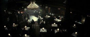 Movie still from “J. Edgar” (2011), directed by Clint Eastwood – People are sitting at tables in a dark restaurant; Extreme Wide shot, High angle
