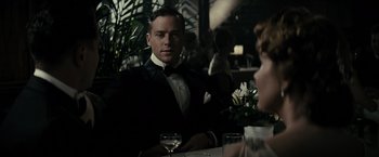 Movie still from “J. Edgar” (2011), directed by Clint Eastwood – A man sitting at a table with a glass of wine; Medium shot, Over the shoulder angle