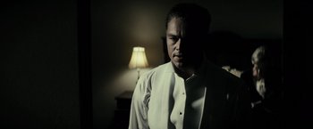 Movie still from “J. Edgar” (2011), directed by Clint Eastwood – A man standing in front of a lamp in a dark room; Close Up shot, Low angle