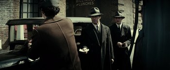 Movie still from “J. Edgar” (2011), directed by Clint Eastwood – A group of men standing next to each other on the street; Medium shot, Over the shoulder angle