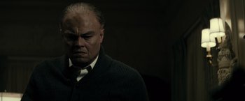 Movie still from “J. Edgar” (2011), directed by Clint Eastwood – An older man in a black sweater and a white shirt; Close Up shot, Low angle