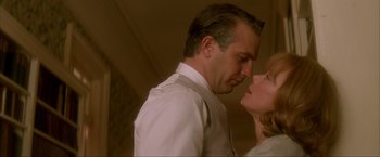 Movie still from “JFK” (1991), directed by Oliver Stone – A man and a woman are kissing in a room; Close Up shot, Low angle