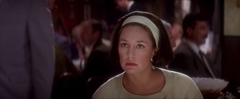 Movie still from “JFK” (1991), directed by Oliver Stone – A person wearing a headband; Close Up shot, Over the shoulder angle