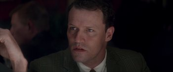 Movie still from “JFK” (1991), directed by Oliver Stone – A person wearing a suit and tie; Close Up shot, Low angle