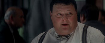 Movie still from “JFK” (1991), directed by Oliver Stone – A person wearing a bow tie; Close Up shot, Low angle