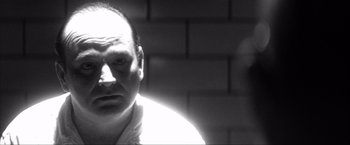 Movie still from “JFK” (1991), directed by Oliver Stone – Black and white photograph of a man in a white shirt; Close Up shot, Low angle