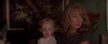 Movie still from “JFK” (1991), directed by Oliver Stone – A woman and a baby are looking at the camera; Close Up shot, Over the shoulder angle
