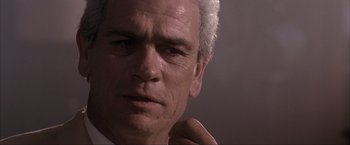 Movie still from “JFK” (1991), directed by Oliver Stone – An older man with white hair is looking at the camera; Close Up shot, Low angle