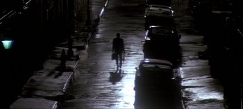 Movie still from “JFK” (1991), directed by Oliver Stone – A man walking down a street holding a briefcase; Extreme Wide shot, Low angle