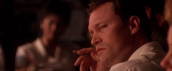 Movie still from “JFK” (1991), directed by Oliver Stone – A person talking on a cell phone; Close Up shot, Low angle