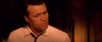 Movie still from “JFK” (1991), directed by Oliver Stone – A person wearing a shirt and a tie; Close Up shot, Low angle
