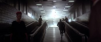 A group of people walking up and down a set of escalators