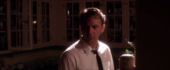 Movie still from “JFK” (1991), directed by Oliver Stone – A man wearing a white dress shirt and a black tie; Close Up shot, Low angle
