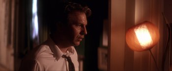 Movie still from “JFK” (1991), directed by Oliver Stone – A person wearing a shirt and a tie; Close Up shot, Low angle