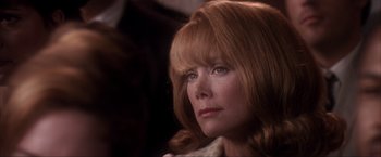 Movie still from “JFK” (1991), directed by Oliver Stone – A person with long red hair; Close Up shot, Over the shoulder angle
