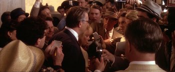 Movie still from “JFK” (1991), directed by Oliver Stone – A group of people standing next to each other in a room; Medium shot, Over the shoulder angle