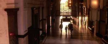 Movie still from “JFK” (1991), directed by Oliver Stone – A group of people walking down a hall way; Extreme Wide shot, Low angle
