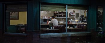 Movie still from “Jack Reacher: Never Go Back” (2016), directed by Edward Zwick – A man standing at a counter in a restaurant; Wide shot, Over the shoulder angle
