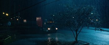 Movie still from “Jack Reacher: Never Go Back” (2016), directed by Edward Zwick – A semi truck driving down a street in the rain; Extreme Wide shot, High angle