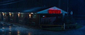 Movie still from “Jack Reacher: Never Go Back” (2016), directed by Edward Zwick – A motel sign lit up at night in the rain; Extreme Wide shot, Low angle