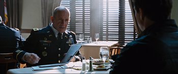 Movie still from “Jack Reacher: Never Go Back” (2016), directed by Edward Zwick – A man in a military uniform sitting at a table; Medium shot, Over the shoulder angle