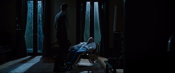 Movie still from “Jack Reacher: Never Go Back” (2016), directed by Edward Zwick – A man laying on a chair in a room; Wide shot, High angle