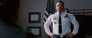 Movie still from “Jack Reacher: Never Go Back” (2016), directed by Edward Zwick – A man in uniform standing in front of an american flag; Medium shot, Low angle