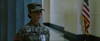 Movie still from “Jack Reacher: Never Go Back” (2016), directed by Edward Zwick – A woman in a military uniform is standing in a hallway; Medium shot, Over the shoulder angle