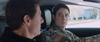 Movie still from “Jack Reacher: Never Go Back” (2016), directed by Edward Zwick – A woman in a uniform sitting next to a man in a car; Close Up shot, Over the shoulder angle