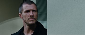 Movie still from “Jack Reacher: Never Go Back” (2016), directed by Edward Zwick – A person standing next to a wall; Close Up shot, Low angle