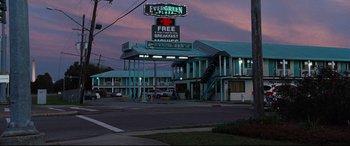 Movie still from “Jack Reacher: Never Go Back” (2016), directed by Edward Zwick – A motel sign is lit up at dusk; Extreme Wide shot, High angle