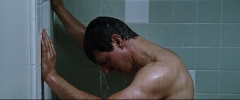 Movie still from “Jack Reacher: Never Go Back” (2016), directed by Edward Zwick – A man taking a shower in a bathroom; Close Up shot, Low angle