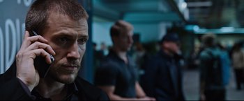 Movie still from “Jack Reacher: Never Go Back” (2016), directed by Edward Zwick – A man in a black shirt is looking at the camera; Close Up shot, Over the shoulder angle