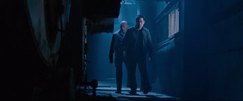 Movie still from “Jack Reacher: Never Go Back” (2016), directed by Edward Zwick – Two men are walking down a dark hallway; Medium shot, Low angle