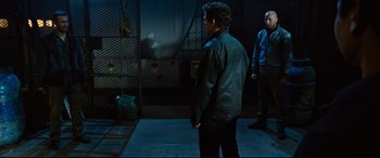 Movie still from “Jack Reacher: Never Go Back” (2016), directed by Edward Zwick – Two men standing next to each other in a dark room; Wide shot, Over the shoulder angle