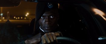 Movie still from “Jack Reacher: Never Go Back” (2016), directed by Edward Zwick – A man in a hat is holding the steering wheel of a car; Close Up shot, Low angle