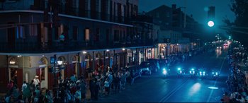 Movie still from “Jack Reacher: Never Go Back” (2016), directed by Edward Zwick – A group of people walking down a street at night; Extreme Wide shot, High angle
